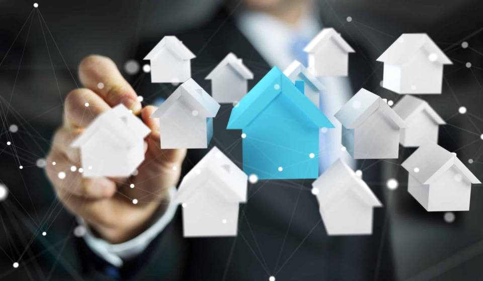 Businessman on blurred background using 3D rendered small white and blue houses